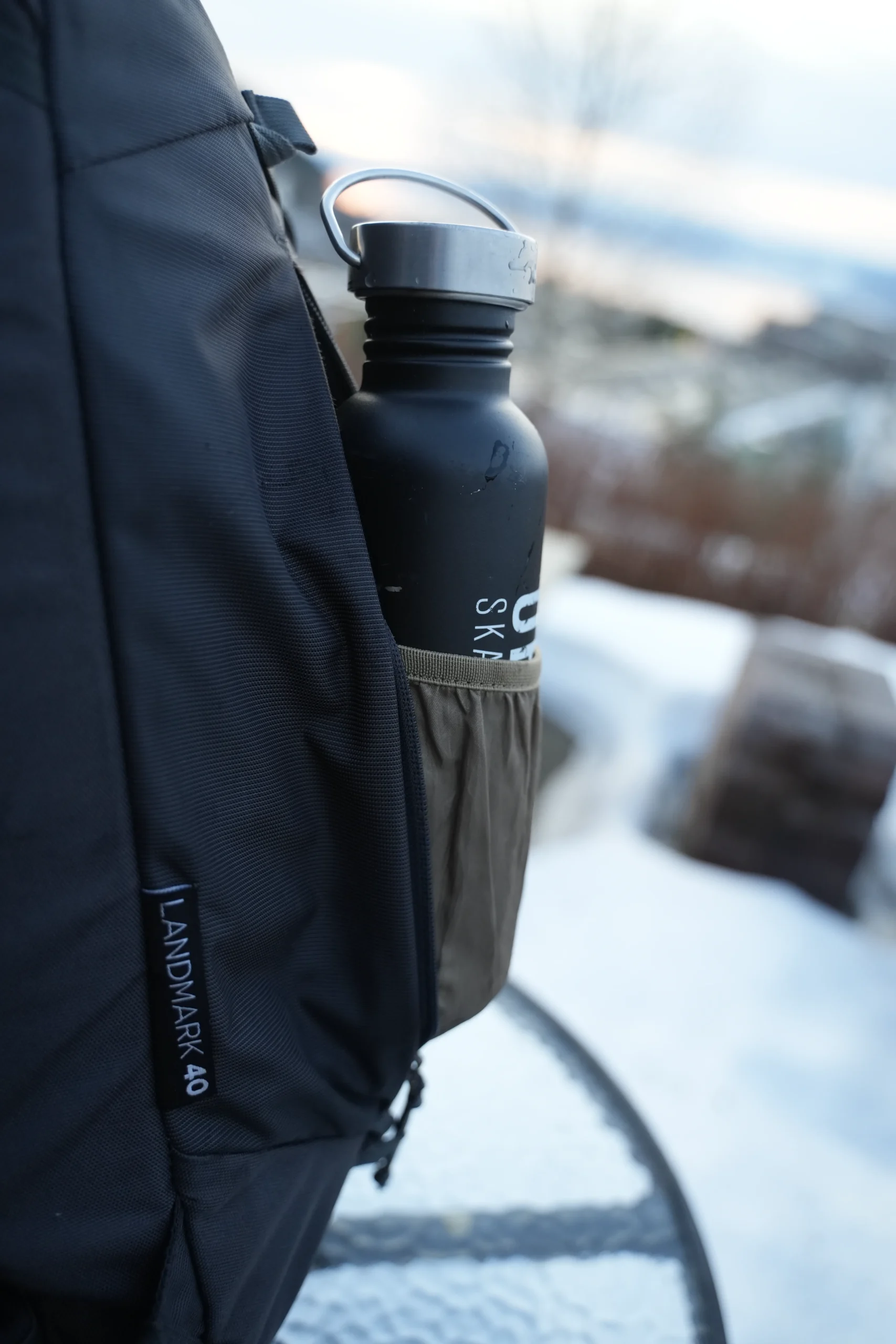 Thule Landmark 40 side pocket with water bottle from side angle