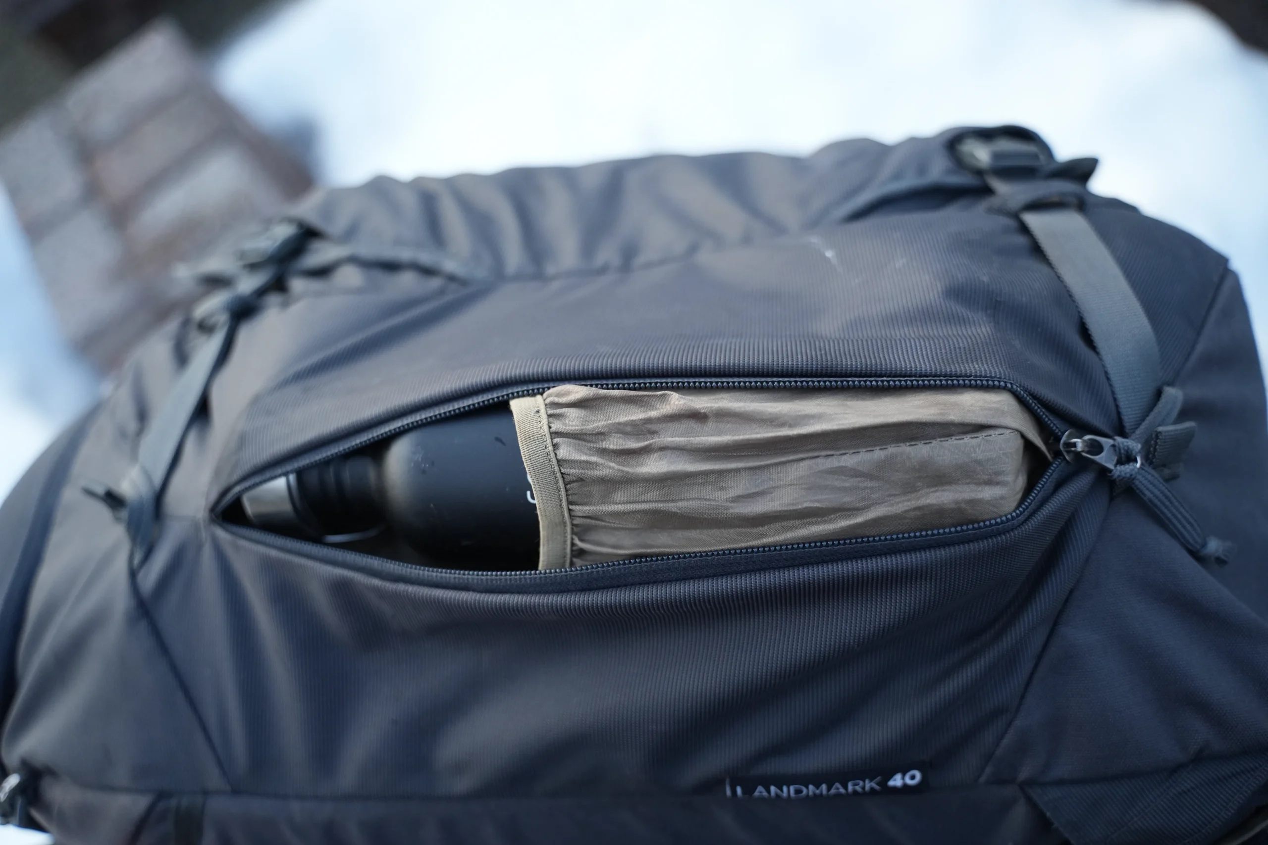 Thule Landmark 40 side pocket unzipped with bottle stowed
