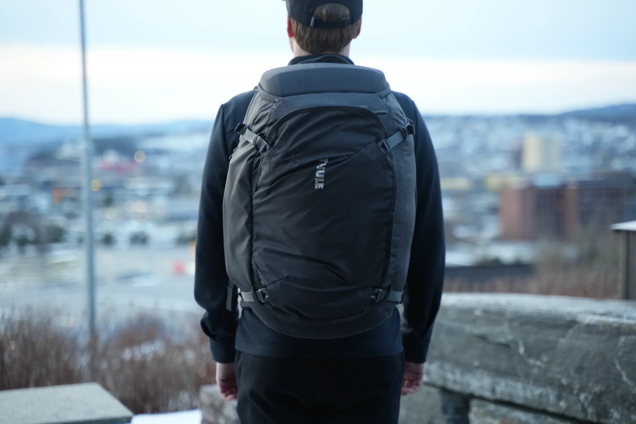 Thule Landmark 40 worn from rear angle with cityscape in background