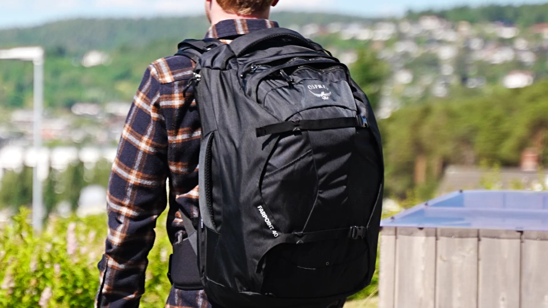 Person wearing the Osprey Farpoint 40 backpack from behind with panoramic city view
