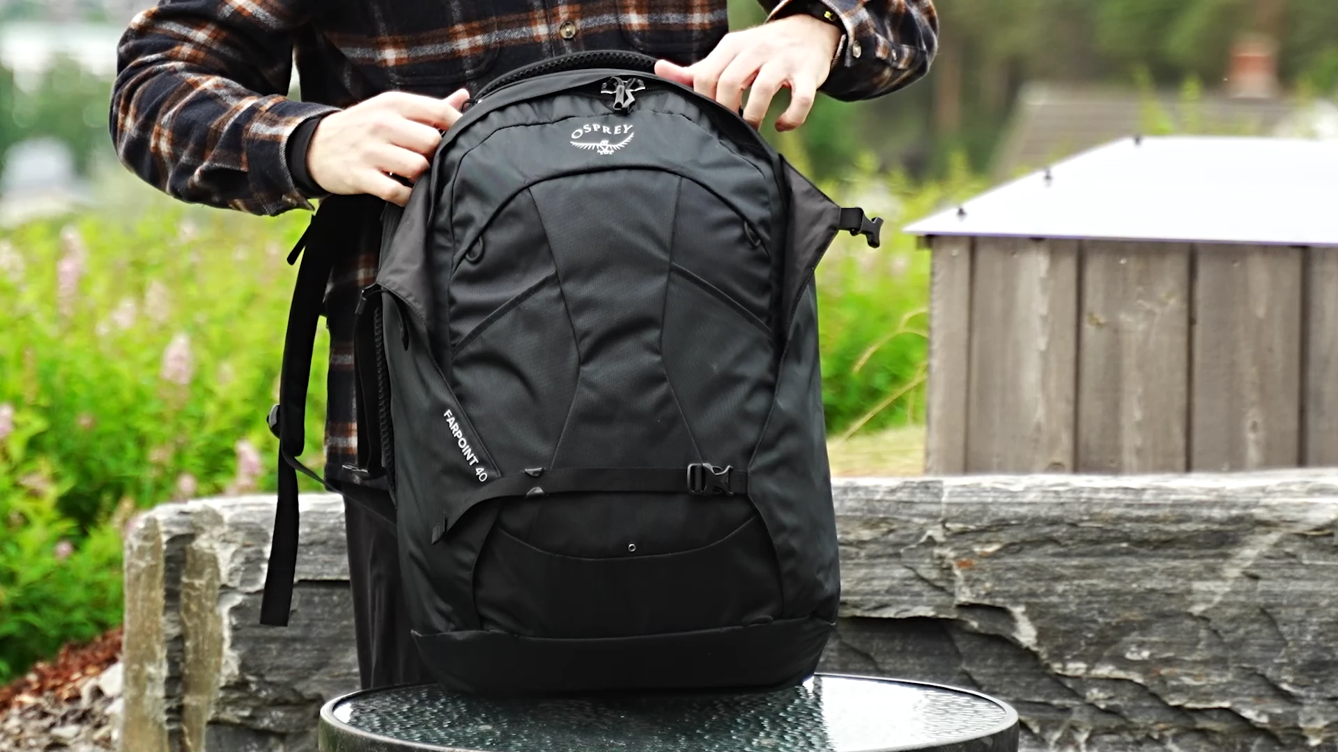 Person presenting the Osprey Farpoint 40 showing the front panel and FARPOINT 40 text
