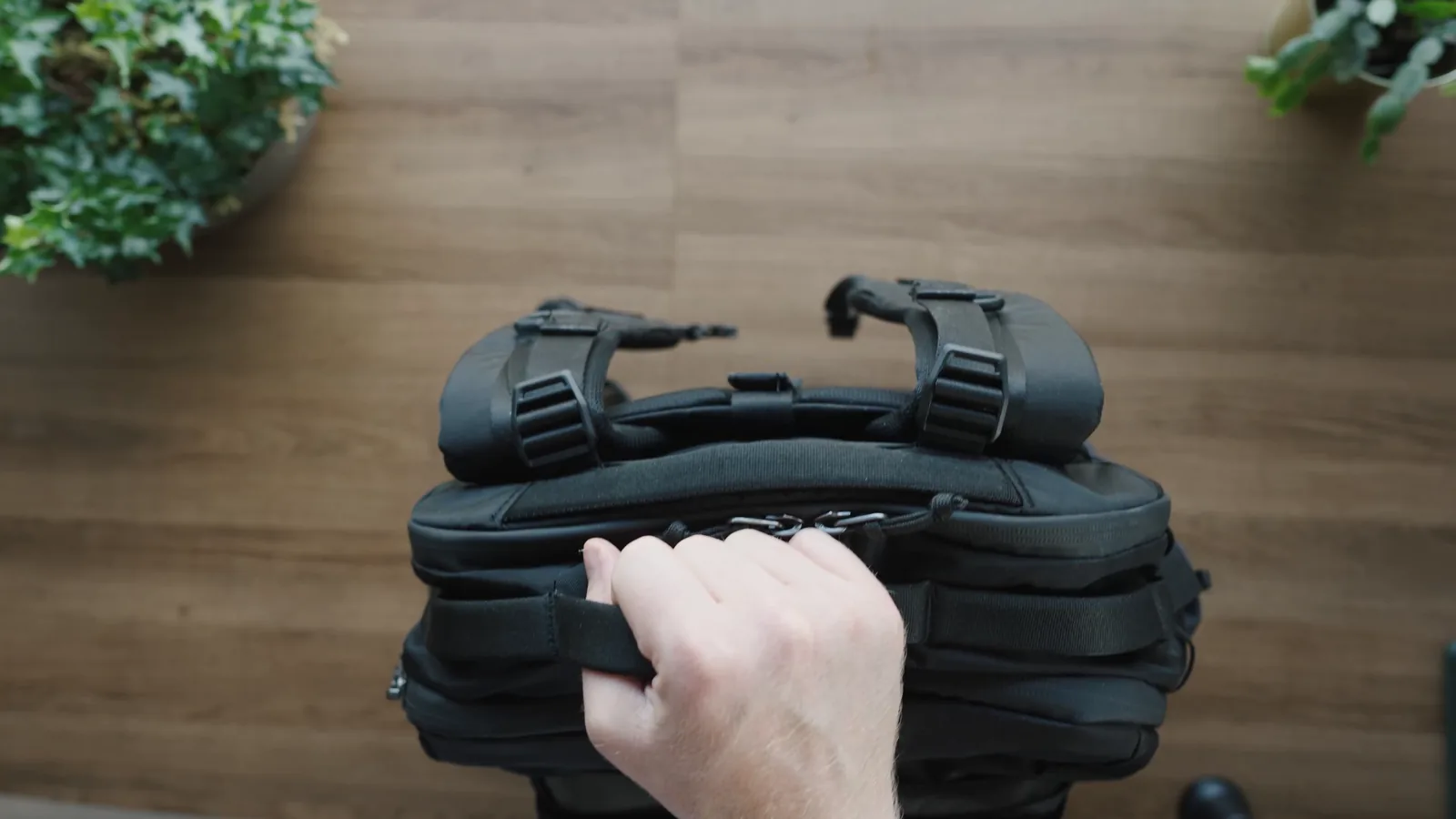 Hand gripping one of the grab handles on the Matador Global Travel Pack 35