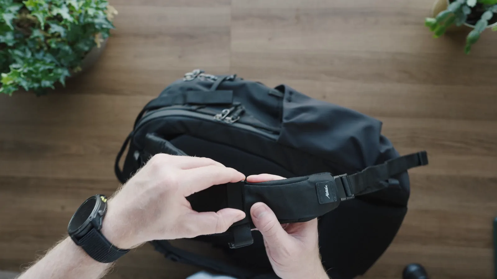 Hands adjusting the sternum strap on the Matador Global Travel Pack 35