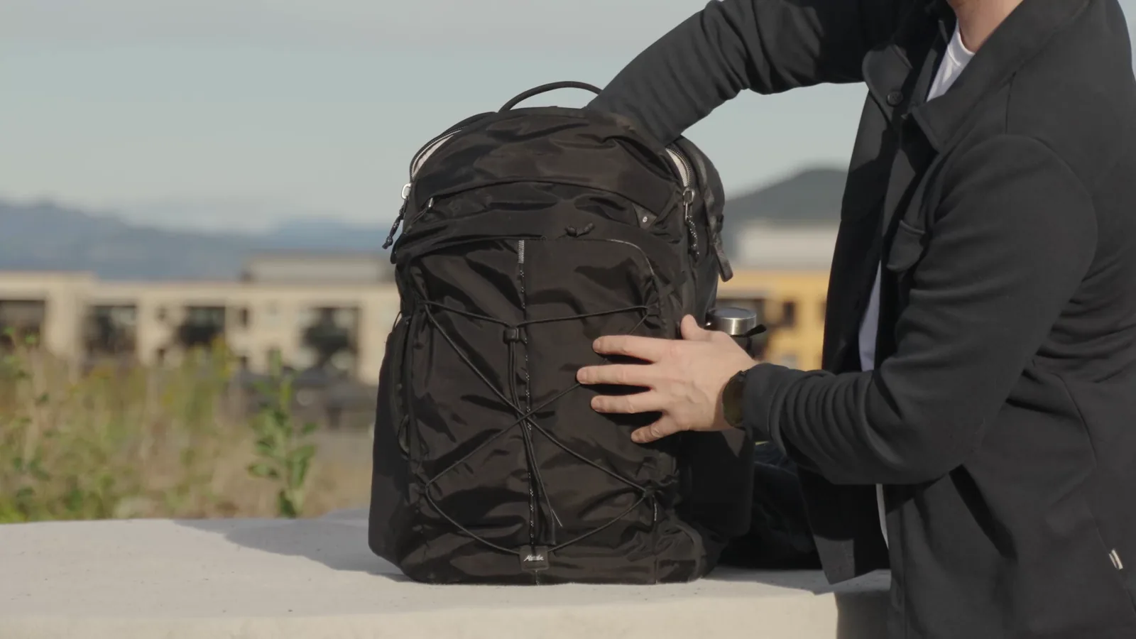 Reaching into the Matador Global Travel Pack 35 from the top while it stands upright