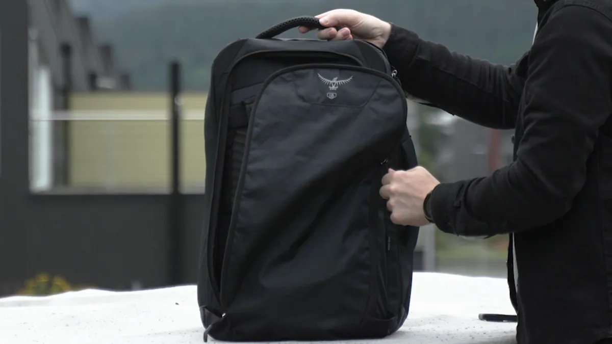 The rear zippered cover of the Osprey Farpoint 40 being opened to reveal the stowed carrying system.