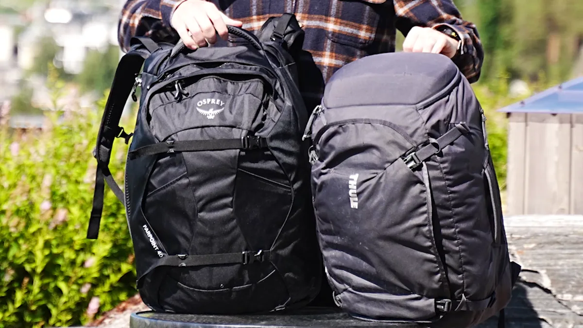 Osprey Farpoint 40 on the left and Thule Landmark 40 on the right, held side by side.